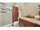 This bathroom offers a tiled shower, a granite countertop sink, and ample lighting at 11055 Ullswater Ln, Windermere, FL 34786