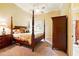 Primary bedroom features a dark wood four poster bed and an ensuite bathroom at 11055 Ullswater Ln, Windermere, FL 34786