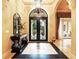 Elegant foyer features a custom door, designer flooring, statement chandelier, and tasteful décor at 11055 Ullswater Ln, Windermere, FL 34786