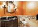 Stylish half bathroom with ornate vanity, decorative mirror, and sconce lighting at 11055 Ullswater Ln, Windermere, FL 34786