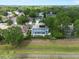 An aerial view showing a home nestled among trees, featuring a screened pool and solar panels on the roof at 1128 Brantley Estates Dr, Altamonte Springs, FL 32714