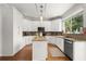 Bright kitchen with white cabinets, stainless appliances, granite countertops and island with bar seating at 1128 Brantley Estates Dr, Altamonte Springs, FL 32714
