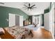 Green main bedroom with hardwood floors, ensuite bathroom access and access to the balcony at 1128 Brantley Estates Dr, Altamonte Springs, FL 32714