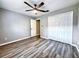 Cozy bedroom with wood-look flooring, ceiling fan, and double door closet at 1200 Montheath Cir, Ocoee, FL 34761