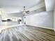 Open living room with vaulted ceilings, stylish ceiling fan, view of the kitchen, and attractive plank flooring at 1200 Montheath Cir, Ocoee, FL 34761