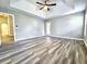 Spacious main bedroom featuring tray ceilings, plank flooring, and a ceiling fan at 1200 Montheath Cir, Ocoee, FL 34761