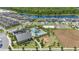 Aerial view of a community with a pool, playground, lake, and basketball and volleyball courts at 12048 Imaginary Way, Orlando, FL 32832