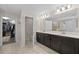 Bathroom with a dual sink vanity, large mirror, and an open doorway to a separate water closet and walk-in closet at 12048 Imaginary Way, Orlando, FL 32832