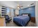 Comfortable bedroom featuring a blue accent wall, ceiling fan, and a large window for ample natural light at 12048 Imaginary Way, Orlando, FL 32832