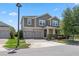 Two-story home featuring a three-car garage, neutral siding, and a covered front porch at 12048 Imaginary Way, Orlando, FL 32832