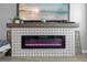 Modern electric fireplace with decorative tile surround and a wooden mantle at 12048 Imaginary Way, Orlando, FL 32832