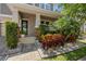 Inviting front porch with manicured bushes and colorful plants, complemented by decorative stone features at 12048 Imaginary Way, Orlando, FL 32832