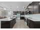 Modern kitchen boasts dark cabinetry, stainless steel appliances, and a stylish island with a sink at 12048 Imaginary Way, Orlando, FL 32832