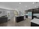 Open-concept kitchen with an island, sleek black cabinets, stainless steel appliances, and a seamless flow to the living area at 12048 Imaginary Way, Orlando, FL 32832