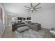 Spacious living room featuring a large sectional sofa, rug, and a view into the dining area and kitchen at 12048 Imaginary Way, Orlando, FL 32832