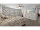 Spacious main bedroom with a ceiling fan, light gray wood-look flooring, and an en-suite bathroom at 12048 Imaginary Way, Orlando, FL 32832