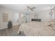 This main bedroom offers neutral walls, wood-look flooring, ceiling fan, and access to a closet and en-suite bath at 12048 Imaginary Way, Orlando, FL 32832