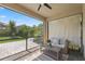 Relaxing screened-in patio with comfortable seating, offering a serene view of the backyard and clear blue skies at 12048 Imaginary Way, Orlando, FL 32832