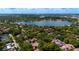 Expansive aerial shot of residences nestled amongst lush foliage with a serene lake backdrop at 1270 Saint Tropez Cir # Ge, Orlando, FL 32806