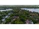 Aerial view showcasing the community nestled amidst mature trees, a lake and surrounding residential homes at 1270 Saint Tropez Cir # Ge, Orlando, FL 32806