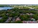 Aerial view capturing the community nestled amidst mature trees, with a picturesque lake in the backdrop at 1270 Saint Tropez Cir # Ge, Orlando, FL 32806