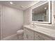 A modern bathroom showcases a vanity with white cabinets, a quartz countertop, and an illuminated mirror at 1270 Saint Tropez Cir # Ge, Orlando, FL 32806