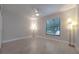 Bright bedroom with light walls, ceiling fan, and window providing natural light and wood-look tile flooring at 1270 Saint Tropez Cir # Ge, Orlando, FL 32806