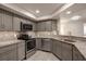 Updated kitchen features gray cabinets, stainless appliances, and granite countertops for a modern look at 1270 Saint Tropez Cir # Ge, Orlando, FL 32806