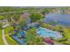 Aerial view of community pool, playground, clubhouse, landscaping, and lake view at 13208 Canna Lily Dr, Orlando, FL 32824