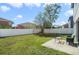 Large backyard featuring green grass, white fence, and patio seating at 13208 Canna Lily Dr, Orlando, FL 32824