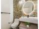 Stylish half bathroom with custom stone accent wall and a modern vessel sink at 13208 Canna Lily Dr, Orlando, FL 32824