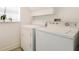 Well-lit laundry room featuring white washer and dryer units, and storage shelf at 13208 Canna Lily Dr, Orlando, FL 32824
