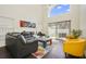 Bright living room with comfortable seating, a large window, and a sliding glass door leading to the backyard at 13208 Canna Lily Dr, Orlando, FL 32824