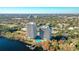 Two lakeside highrise condominiums featuring a large pool deck and dock, surrounded by lush trees at 13427 Blue Heron Beach Dr # 1205, Orlando, FL 32821