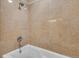 Bathtub with shower features tiled walls at 13427 Blue Heron Beach Dr # 1205, Orlando, FL 32821