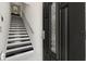 Welcoming entryway featuring a modern staircase with black and white steps, next to a decorative front door at 13429 Fountainbleau Dr # 13429, Clermont, FL 34711