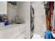 Well-organized laundry room with a sink, counter space, and stacked washer and dryer at 13429 Fountainbleau Dr # 13429, Clermont, FL 34711