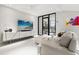 Bright living room featuring a modern entertainment center and a glass-enclosed office space at 13429 Fountainbleau Dr # 13429, Clermont, FL 34711