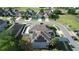 Aerial view of house with solar panels; lush trees and well-manicured yards surround neighborhood at 13520 Meadow Bay Loop, Orlando, FL 32824
