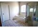 Bright bathroom featuring a tiled floor, garden tub with tiled surround, and glass enclosed shower at 13520 Meadow Bay Loop, Orlando, FL 32824