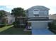 Two-story home with brick and stucco exterior, attached garage, and manicured landscaping at 13520 Meadow Bay Loop, Orlando, FL 32824