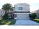 Two-story home featuring a large driveway, a 2-car garage, and a beautiful lawn with mature landscaping at 13520 Meadow Bay Loop, Orlando, FL 32824