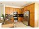 Kitchen with stainless steel appliances, tile floors, granite countertops, and wood cabinetry at 13520 Meadow Bay Loop, Orlando, FL 32824