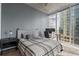 Modern bedroom with a gray color scheme, desk and city views from the large window at 155 S Court Ave # 1202, Orlando, FL 32801