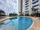 Resort-style pool with surrounding lounge area and modern building backdrop under a bright sky at 155 S Court Ave # 1202, Orlando, FL 32801