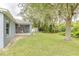Large backyard features a screened porch, mature trees, green grass, and a storage shed at 157 Long Pine Dr, Deltona, FL 32725