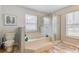 Bathroom featuring a soaking tub with tile surround, glass enclosed shower, and wood look flooring at 157 Long Pine Dr, Deltona, FL 32725
