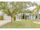 Charming home featuring mature landscaping, a stone walkway, and an attached two car garage at 157 Long Pine Dr, Deltona, FL 32725