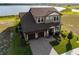 Aerial view of a two-story home showcasing manicured lawn, a three-car garage, and lake views at 200 Valencia Ridge Dr, Auburndale, FL 33823