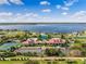 Aerial view of a community pool and tennis court complex surrounded by a serene lake and lush landscapes at 200 Valencia Ridge Dr, Auburndale, FL 33823